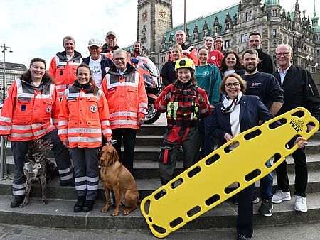 Eine große Gruppe von DRK-Mitarbeitern steht vor dem Hamburger Rathaus.